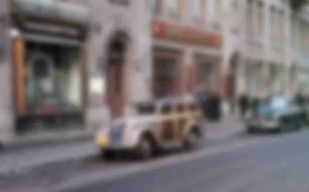 A wood-panelled wagon parked in front of an Azerbaijani wine shop, unknown location.