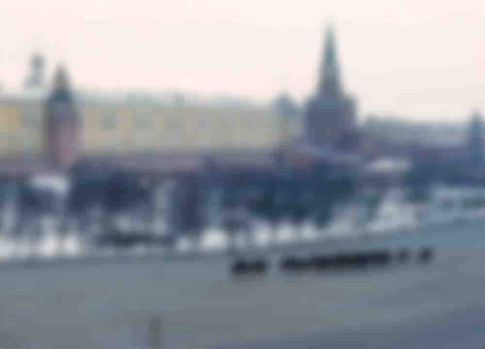 A band of horsemen trotting in front of the walls of the Kremlin.